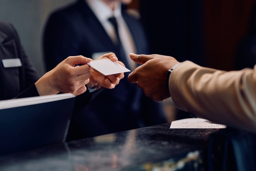 Close,Up,Of,Hotel,Receptionist,Giving,Room,Cardkey,To,African